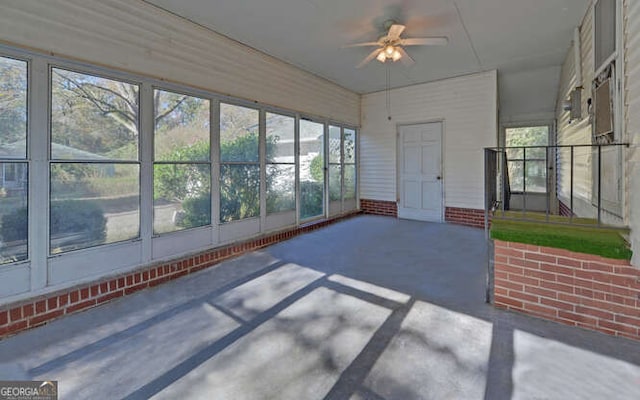 unfurnished sunroom featuring ceiling fan