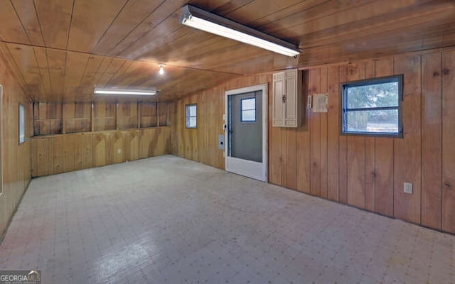 interior space with plenty of natural light, wooden ceiling, and wooden walls