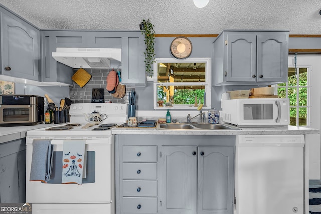 kitchen with white appliances, extractor fan, sink, and a wealth of natural light