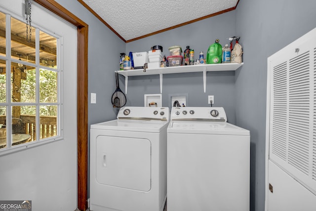 laundry room with ornamental molding, independent washer and dryer, and a textured ceiling