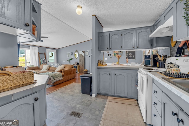 kitchen with gray cabinets, a textured ceiling, light hardwood / wood-style floors, and white range oven