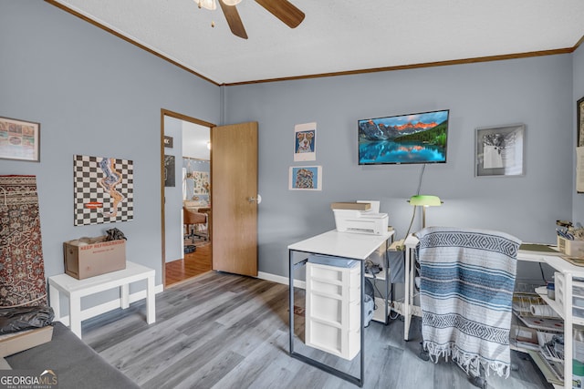 office area with ornamental molding, a textured ceiling, wood-type flooring, and ceiling fan