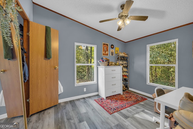 office area with ornamental molding, hardwood / wood-style floors, vaulted ceiling, a textured ceiling, and ceiling fan