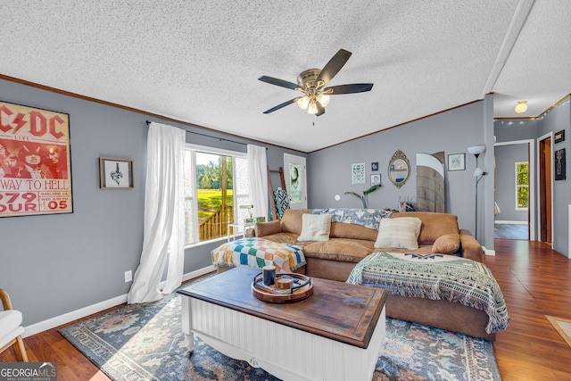 living room with a textured ceiling, crown molding, wood-type flooring, and ceiling fan