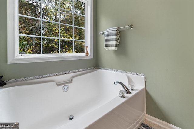 full bathroom with baseboards and a bath