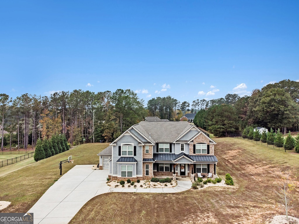 view of front of home with a garage, a front yard, and a porch