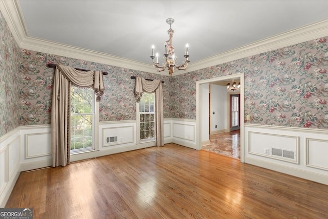 unfurnished dining area with wainscoting and wallpapered walls