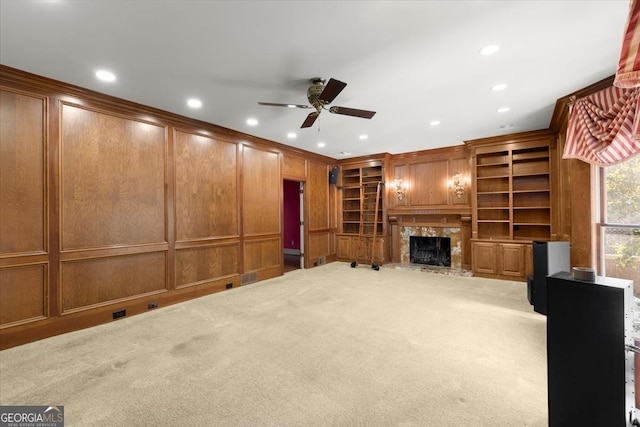 unfurnished living room with crown molding, carpet flooring, a fireplace, a decorative wall, and recessed lighting