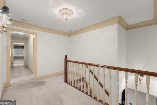 hallway with attic access, ornamental molding, light carpet, an upstairs landing, and baseboards