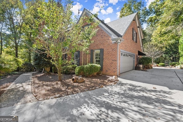 view of front facade with an attached garage, concrete driveway, and brick siding