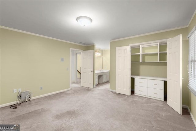 unfurnished bedroom with carpet flooring, crown molding, ensuite bath, and baseboards