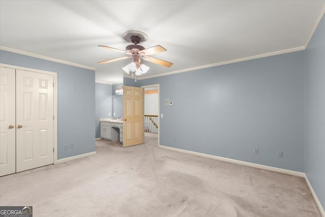 unfurnished bedroom with ceiling fan, light colored carpet, baseboards, a closet, and crown molding