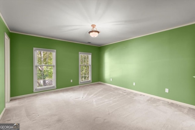 unfurnished room featuring carpet floors, baseboards, and crown molding