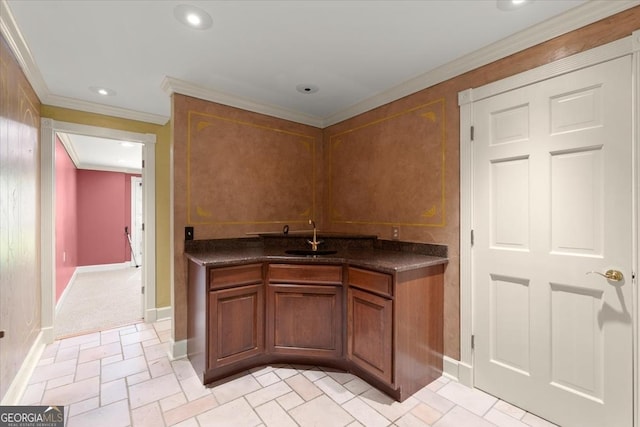 kitchen featuring recessed lighting, a sink, ornamental molding, brown cabinets, and dark countertops