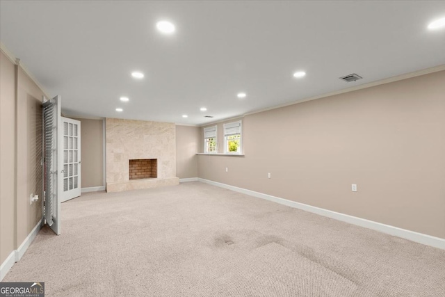 unfurnished living room with recessed lighting, a large fireplace, light colored carpet, and baseboards