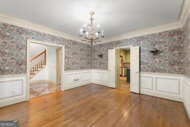 unfurnished dining area featuring wallpapered walls and wainscoting