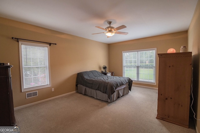 carpeted bedroom with visible vents, ceiling fan, and baseboards