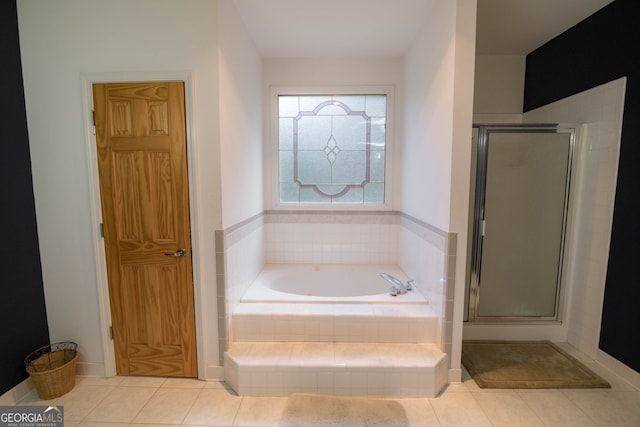 bathroom featuring tile patterned floors, a shower stall, and a bath