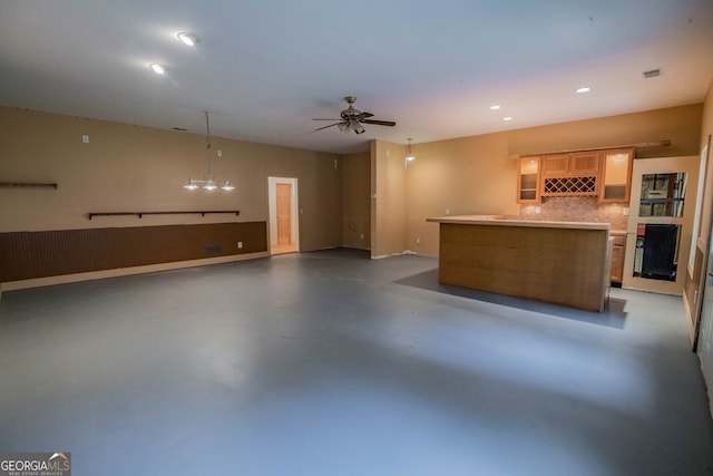 interior space featuring finished concrete flooring, ceiling fan, glass insert cabinets, a center island, and recessed lighting