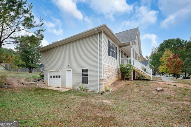 view of side of home featuring a garage and a lawn