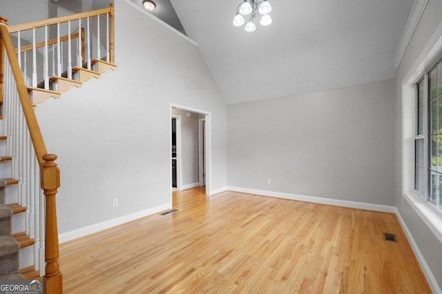 interior space with ornamental molding, hardwood / wood-style floors, a notable chandelier, and high vaulted ceiling