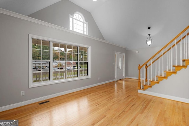 unfurnished living room with crown molding, wood-type flooring, and vaulted ceiling