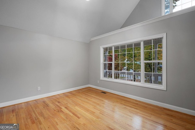 spare room featuring lofted ceiling and hardwood / wood-style floors