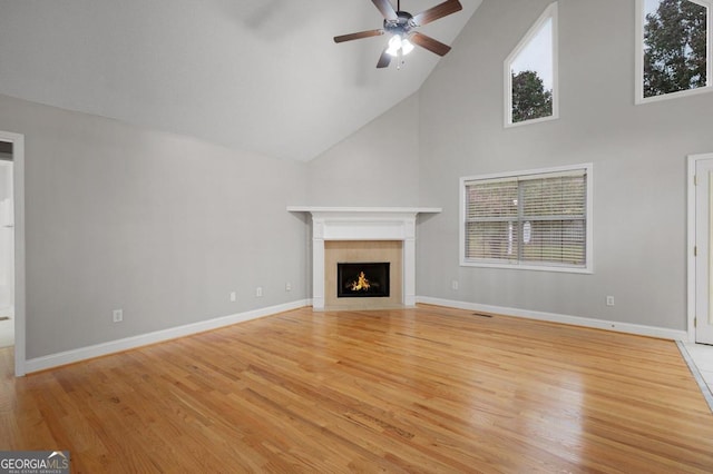 unfurnished living room with a wealth of natural light, light hardwood / wood-style floors, high vaulted ceiling, and ceiling fan