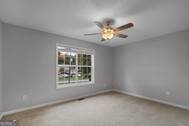 carpeted empty room with a textured ceiling and ceiling fan