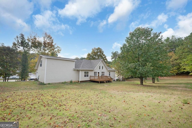 back of house with a wooden deck and a lawn