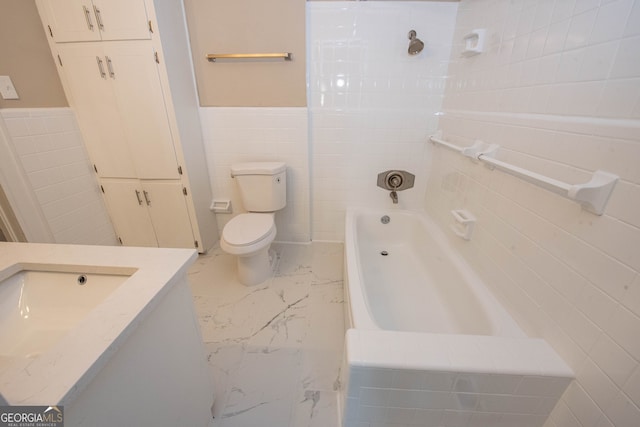 full bathroom featuring  shower combination, vanity, toilet, and tile walls