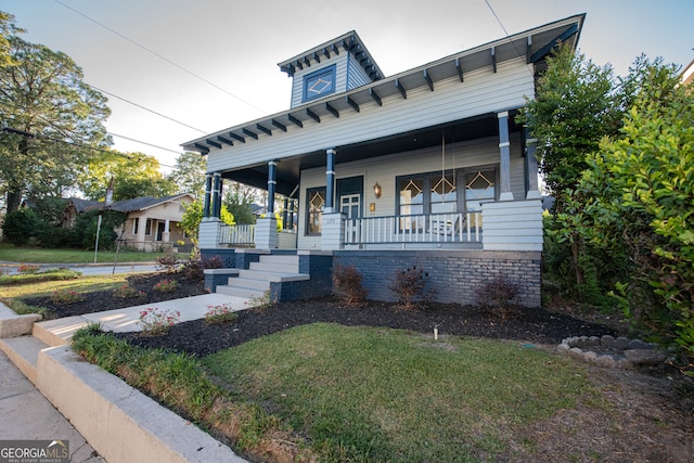 view of front of home featuring covered porch and a front yard