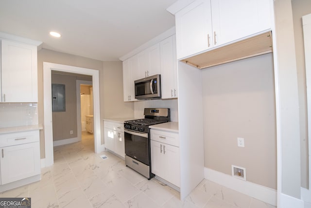 kitchen with white cabinetry, stainless steel appliances, and tasteful backsplash