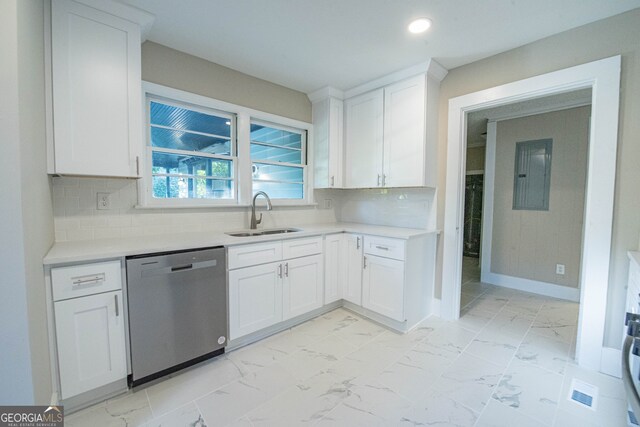 kitchen with tasteful backsplash, sink, stainless steel dishwasher, and white cabinets