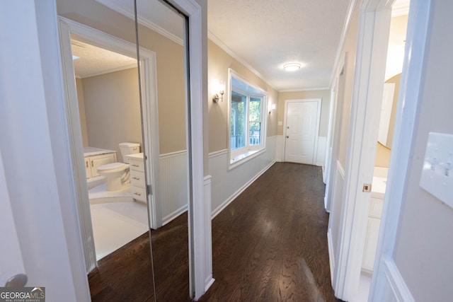 hall featuring ornamental molding, a textured ceiling, and dark wood-type flooring