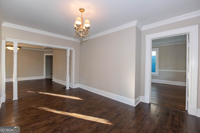 unfurnished room with an inviting chandelier, ornamental molding, dark wood-type flooring, and ornate columns