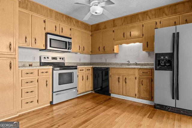 kitchen featuring ceiling fan, light countertops, a sink, light wood-style floors, and stainless steel appliances