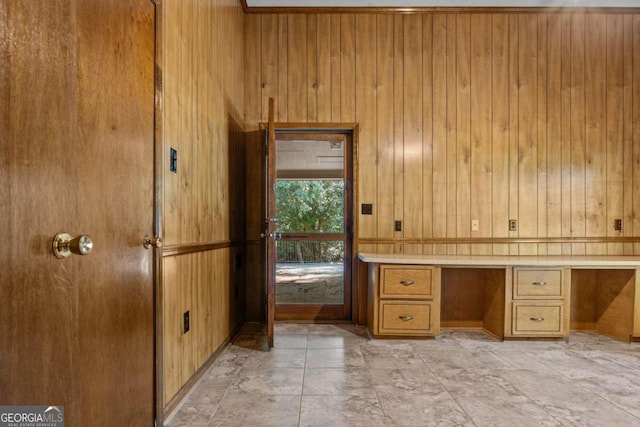 unfurnished office with wooden walls and built in desk