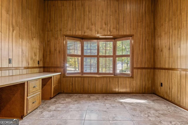 interior space featuring built in study area and wood walls