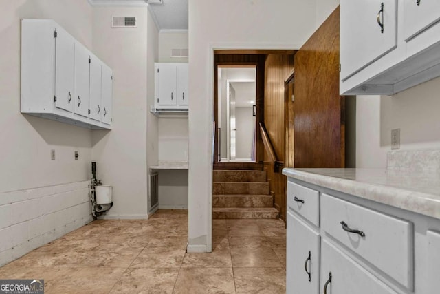 kitchen with visible vents, light countertops, white cabinetry, and ornamental molding