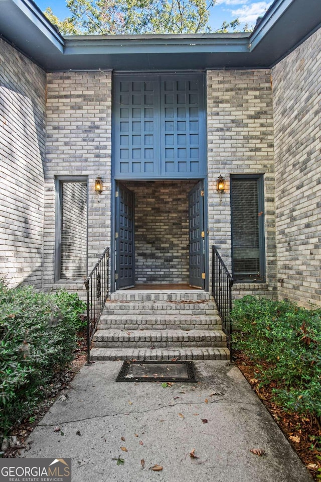 view of exterior entry with brick siding