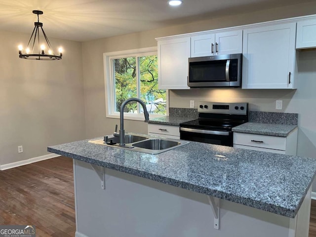 kitchen featuring sink, dark hardwood / wood-style flooring, hanging light fixtures, stainless steel appliances, and white cabinets