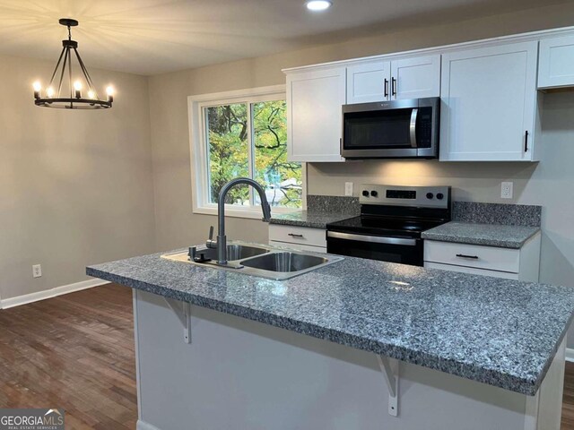 3666 Elkridge Dr, Decatur, GA 30032 - kitchen featuring white cabinets, appliances with stainless steel finishes, a sink, a kitchen breakfast bar, and dark wood finished floors