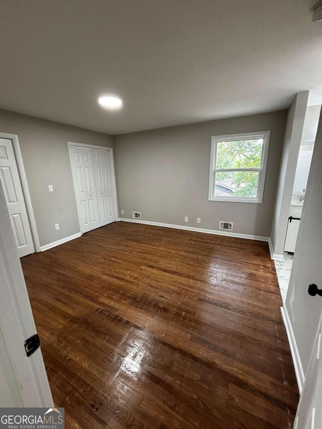 unfurnished bedroom featuring dark hardwood / wood-style flooring