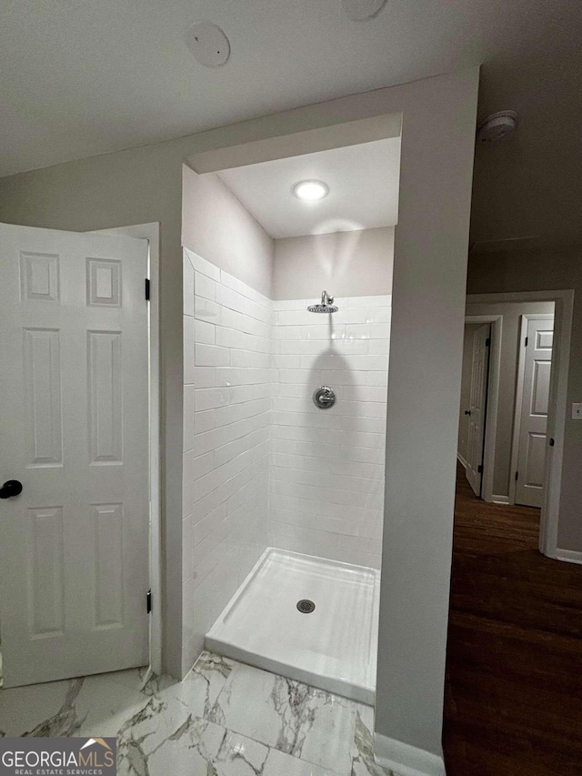 bathroom featuring a tile shower and hardwood / wood-style flooring