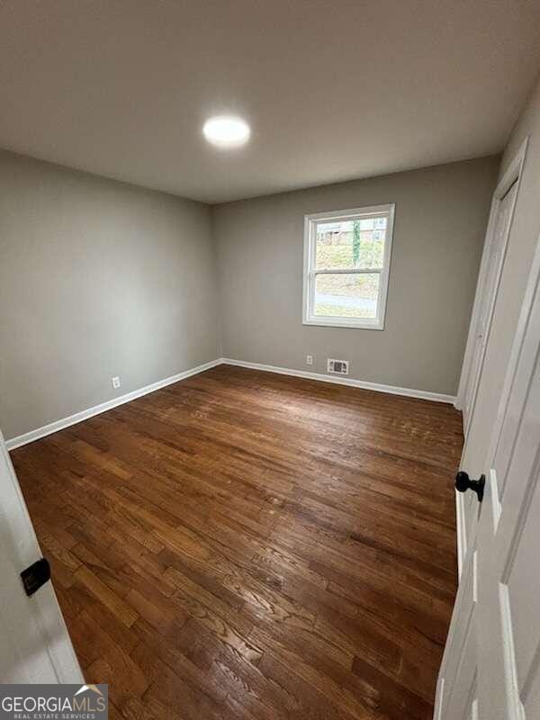 unfurnished bedroom with dark wood-type flooring