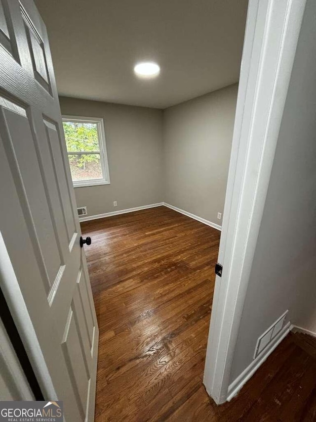 spare room featuring dark hardwood / wood-style flooring