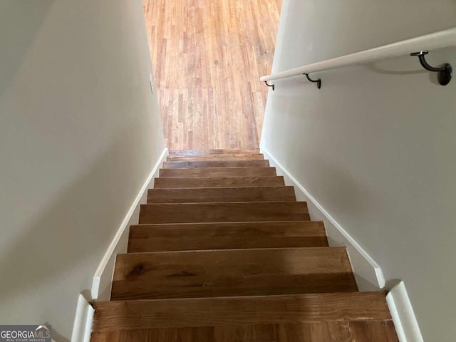 staircase with hardwood / wood-style flooring