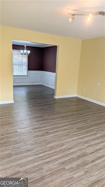 empty room featuring hardwood / wood-style flooring and an inviting chandelier