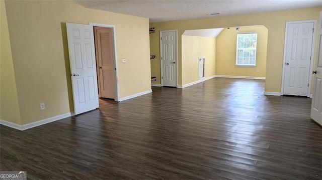 empty room with dark hardwood / wood-style floors and a textured ceiling